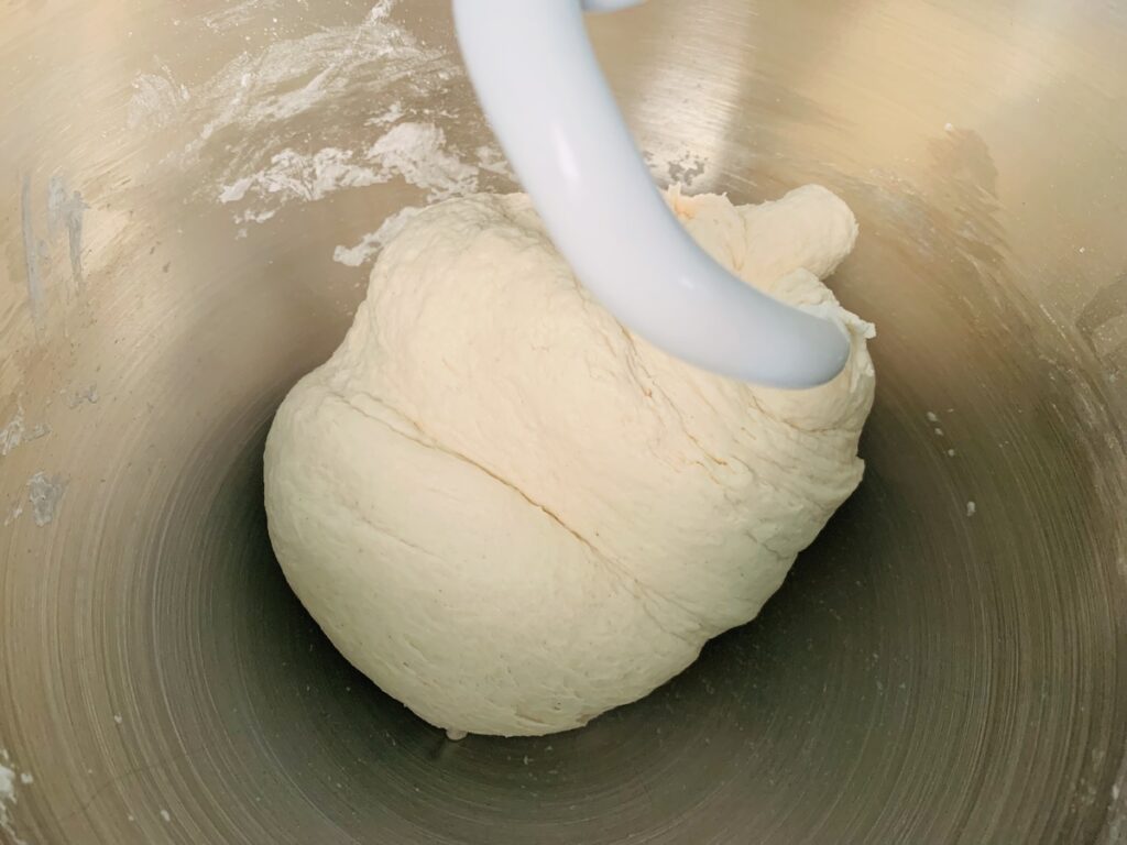 Dough mixed into a ball by a stand mixer dough hook.